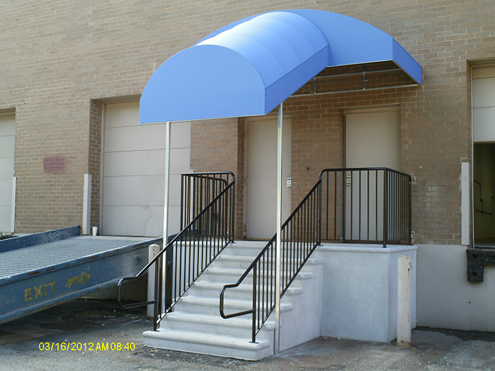 light blue canopy that extends out over the stairs to the building entrance
